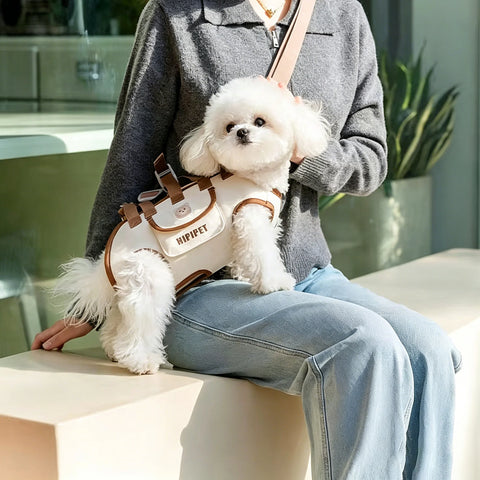 Woman wearing the dog carrier crossbody with a small white dog